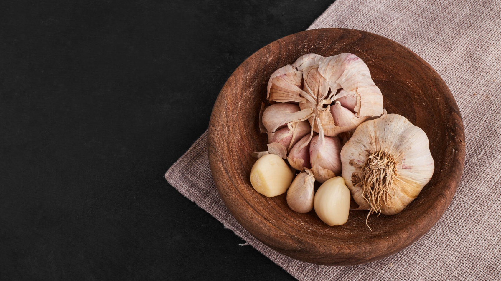 Garlic cloves in a wooden cup, top view. High quality photo