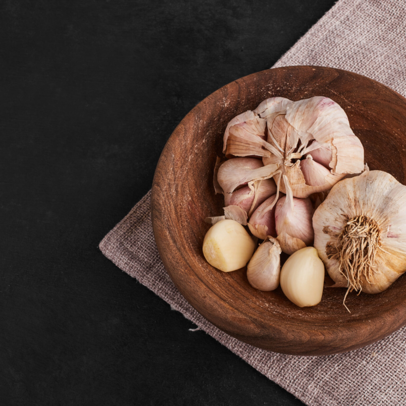 Garlic cloves in a wooden cup, top view. High quality photo